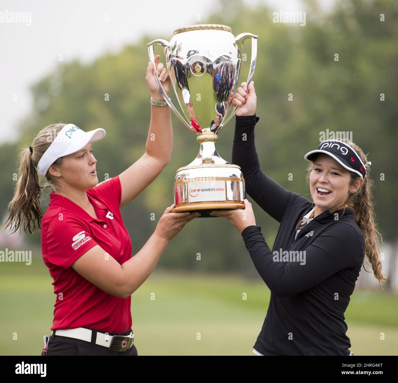 Brooke Henderson of Smiths Falls, ON, left, hoist the trophy with her