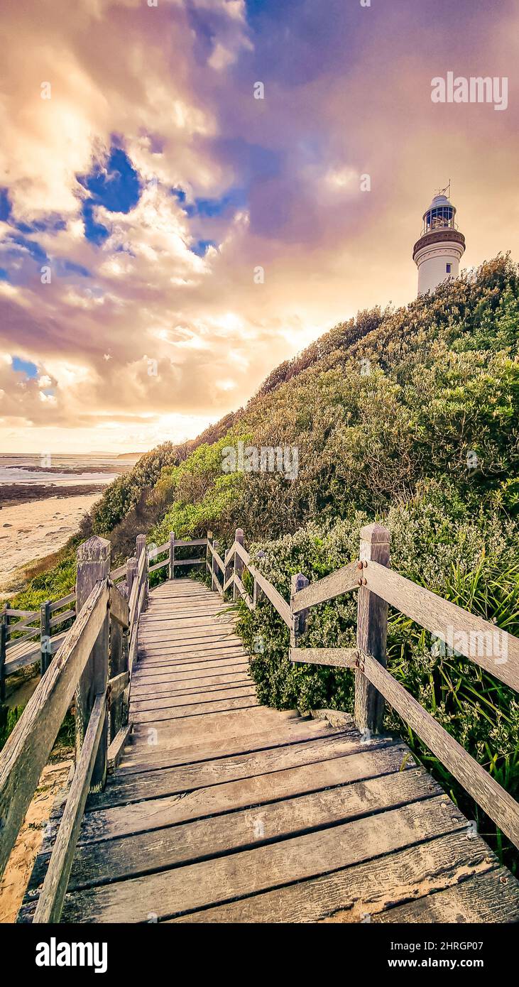 View of a wooden pathway with a lighthouse in the background Stock ...