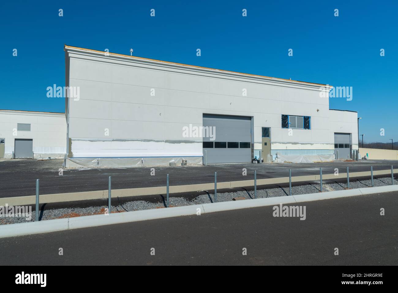 Horizontal shot of an industrial construction project with overhead doors nearing completion. Stock Photo