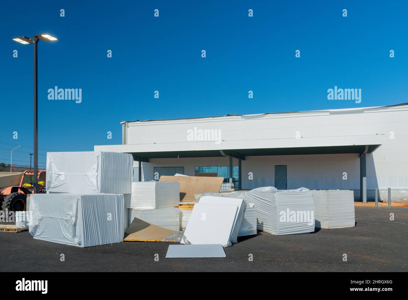 Horizontal shot of packages of new sheet rock that have been delivered to a commercial construction site. Stock Photo