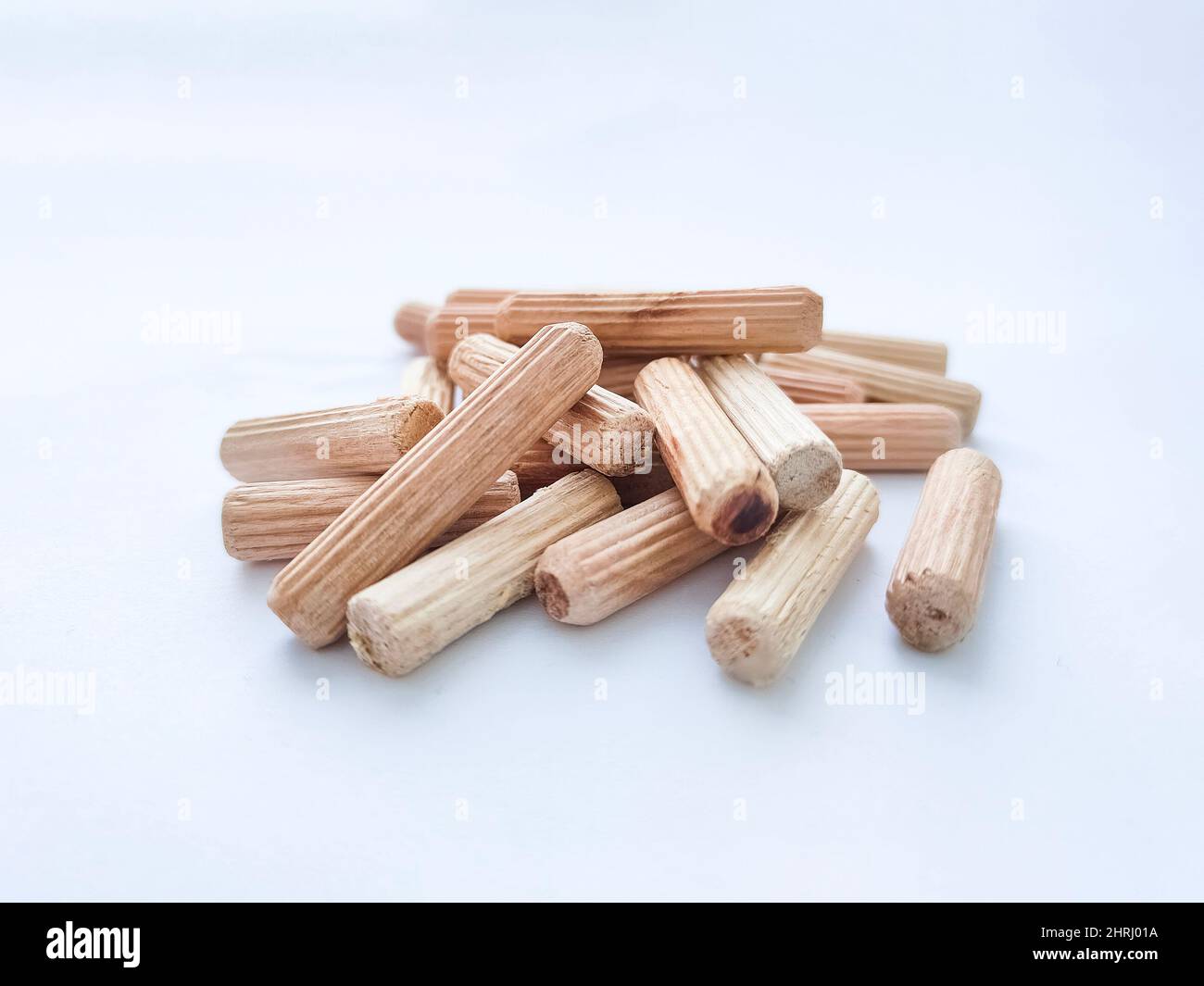 Wooden dowels for assembling furniture on white background. Front view. Selective focus Stock Photo