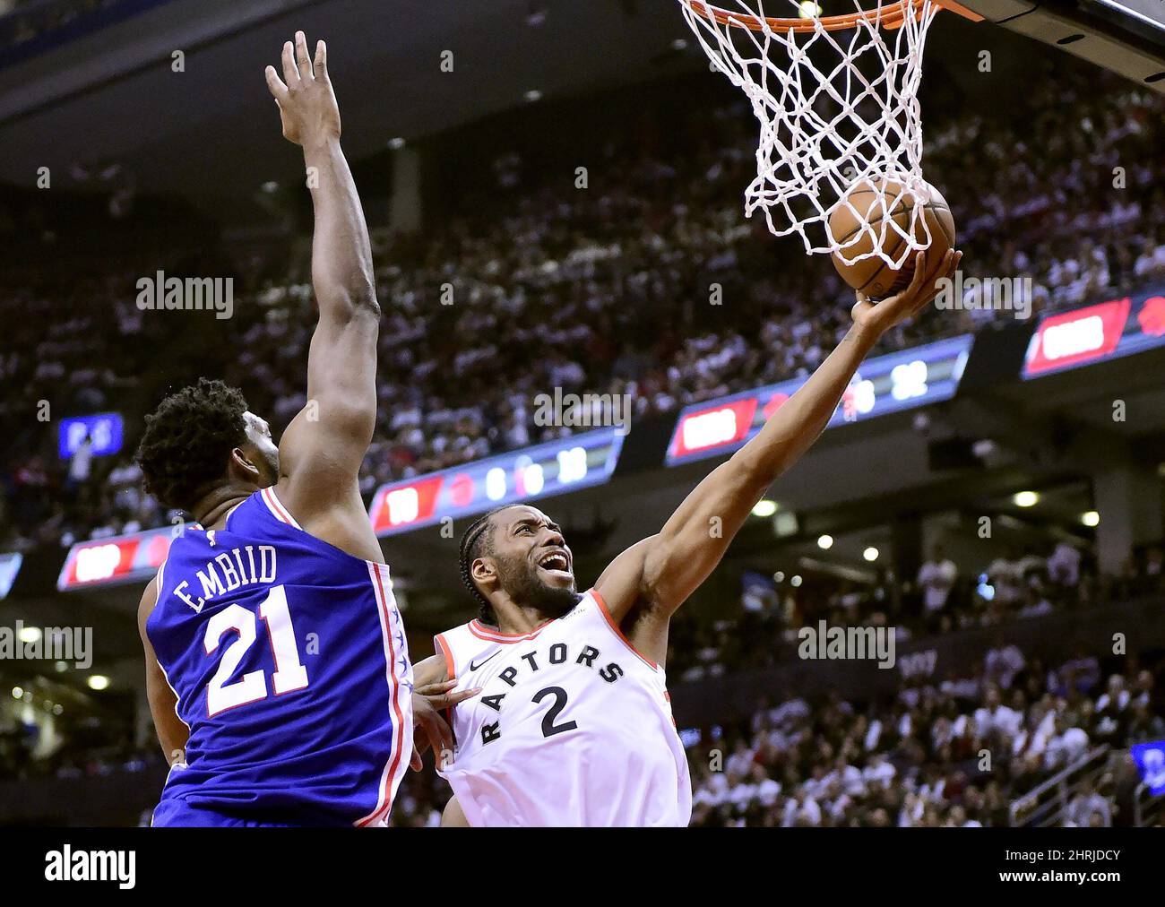 Toronto Raptors forward Kawhi Leonard (2) drives for the layup as Philadelphia 76ers centre Joel Embiid (21) defends during second half NBA Eastern Conference playoff action, in Toronto on Saturday, April 27, 2019. THE CANADIAN PRESS/Frank Gunn Stock Photo