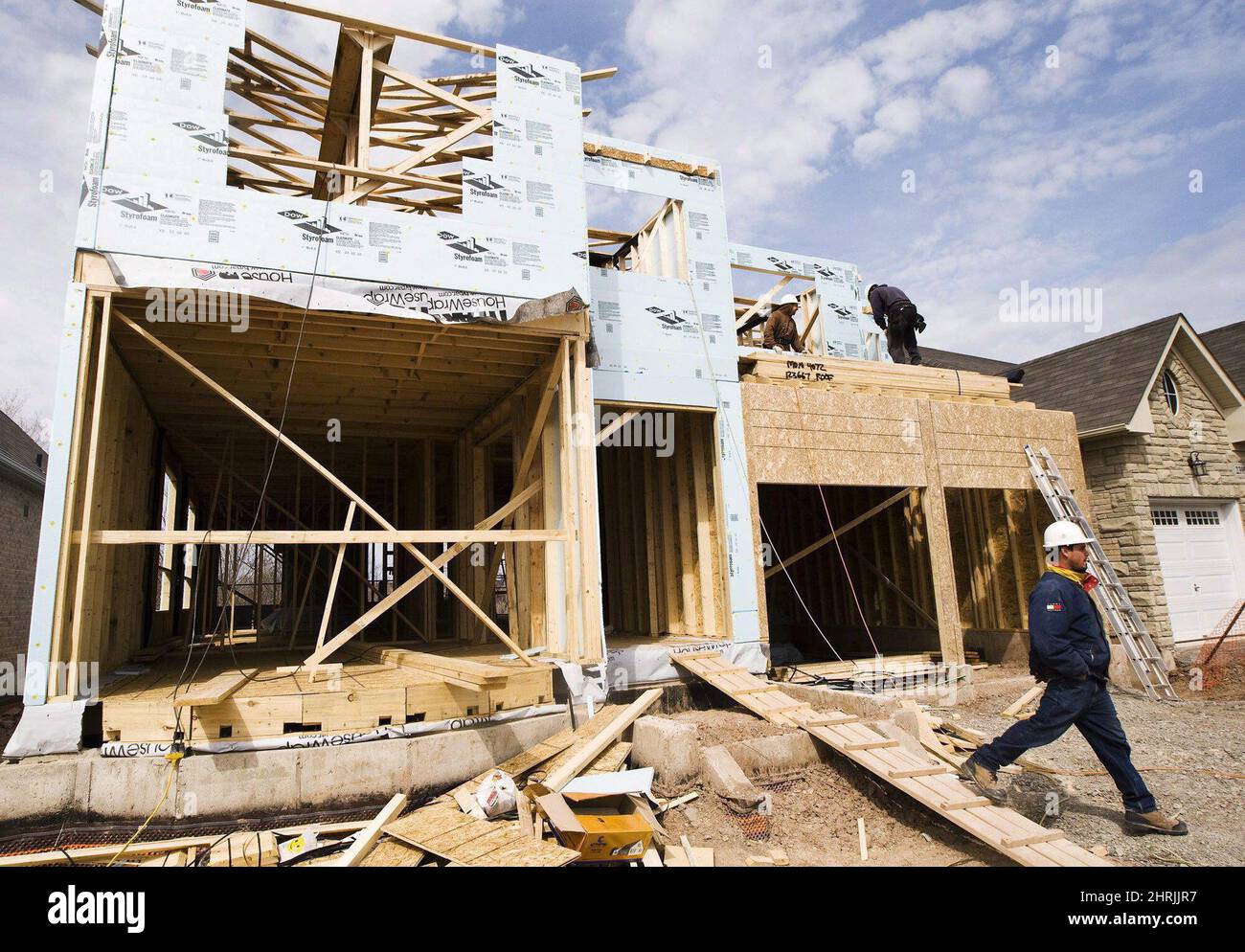 Construction workers build a new home in Oakville, Ont., on April 14 ...
