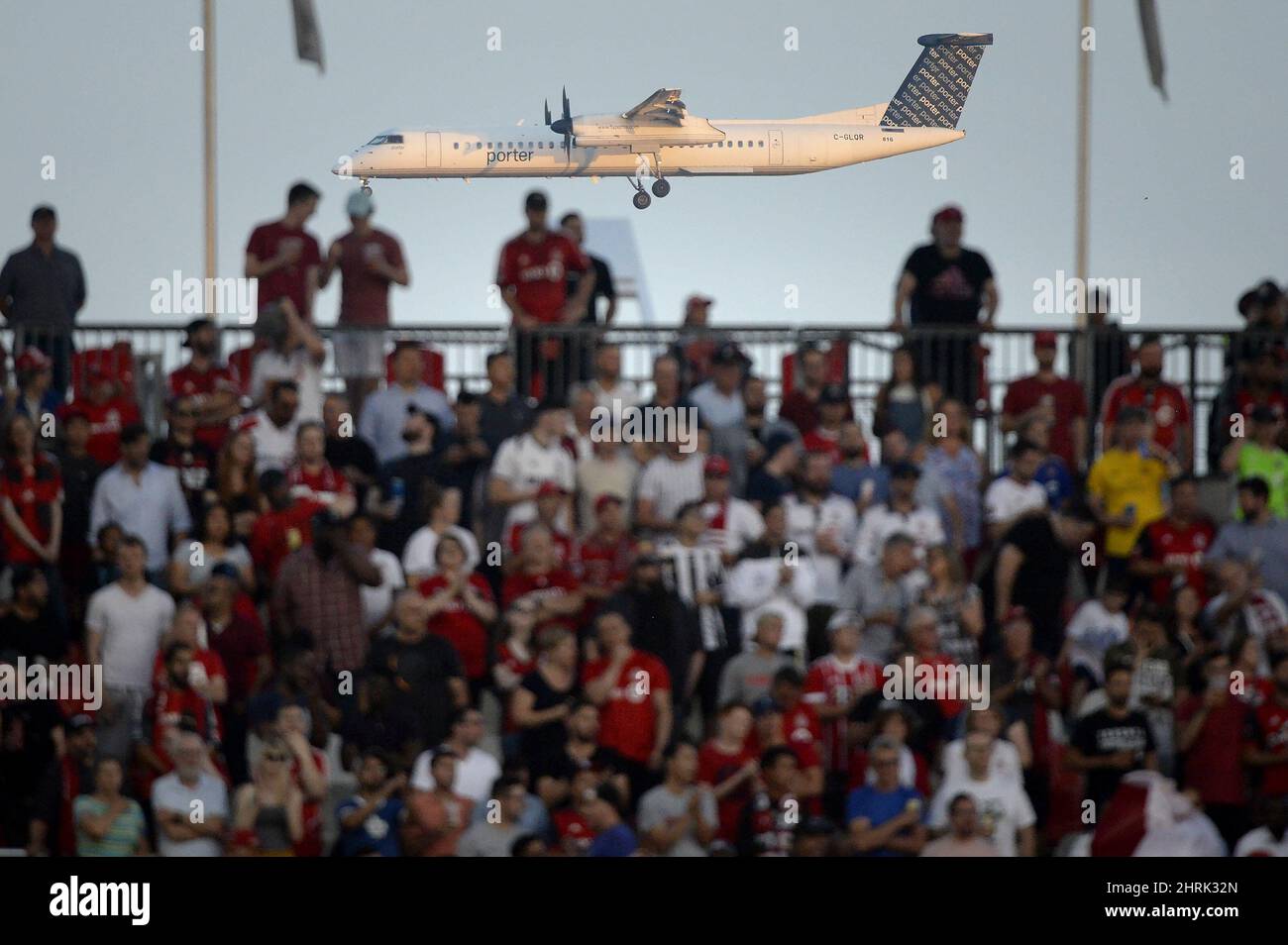 A Porter aircraft on final approach is seen as fans watch first half MLS Soccer action between the Toronto FC and the New York Red Bulls, in Toronto on Wednesday, July 17, 2019. THE CANADIAN PRESS/Nathan Denette Stock Photo