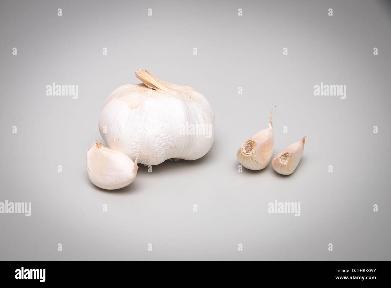 Whole garlic and three cloves with a gray background Stock Photo - Alamy