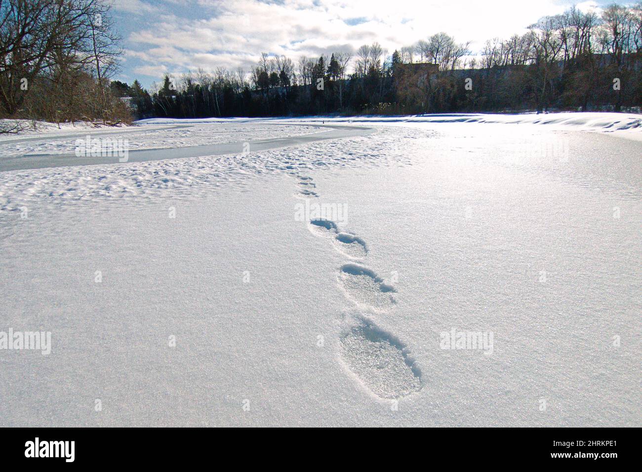 Footprints in loose snow in top of a frozen lake. Stock Photo