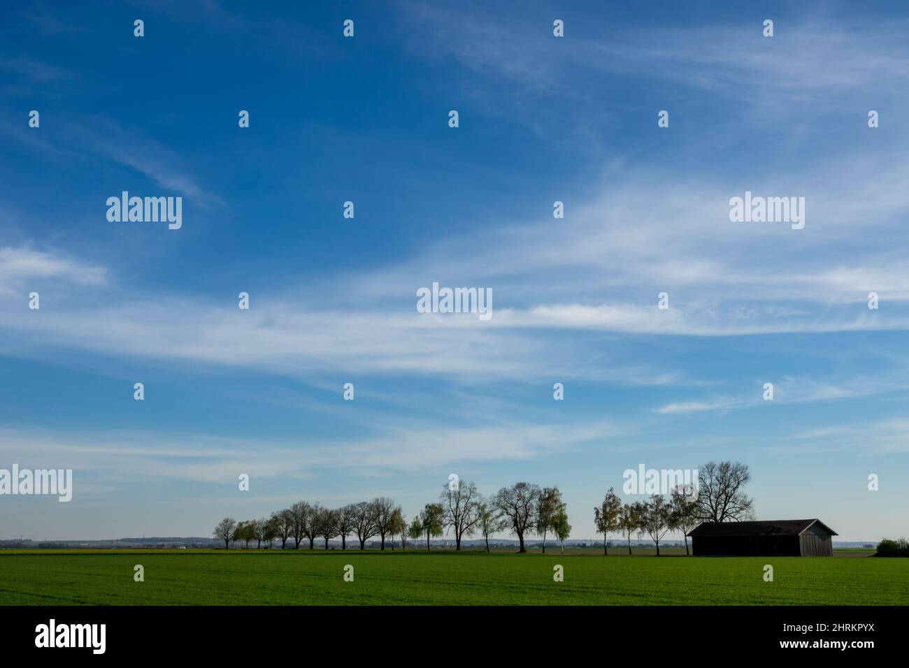 Cloudy blue sky over a green landscape field Stock Photo - Alamy