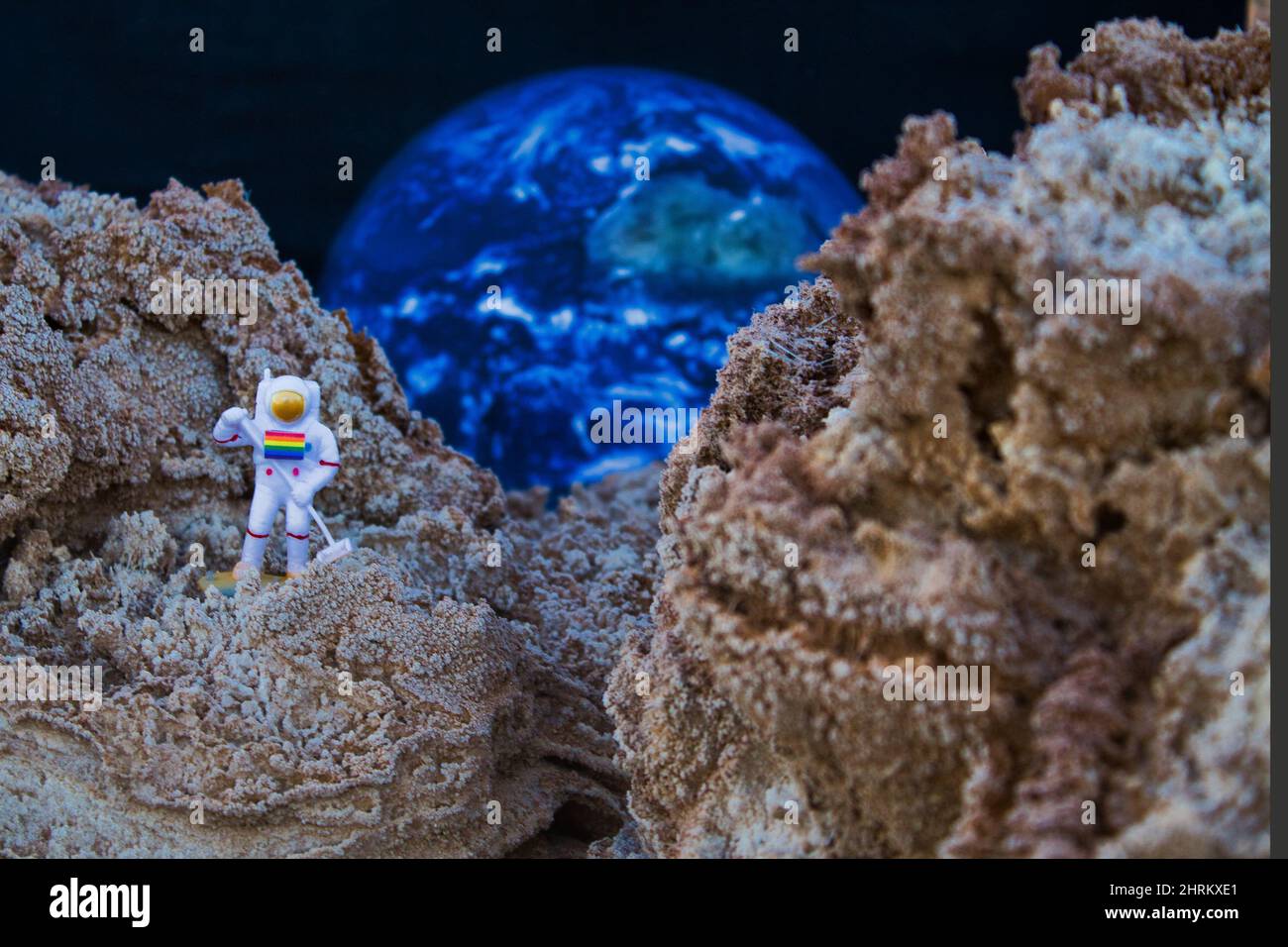 Astronaut miniature on planet Mars with Earth background Stock Photo