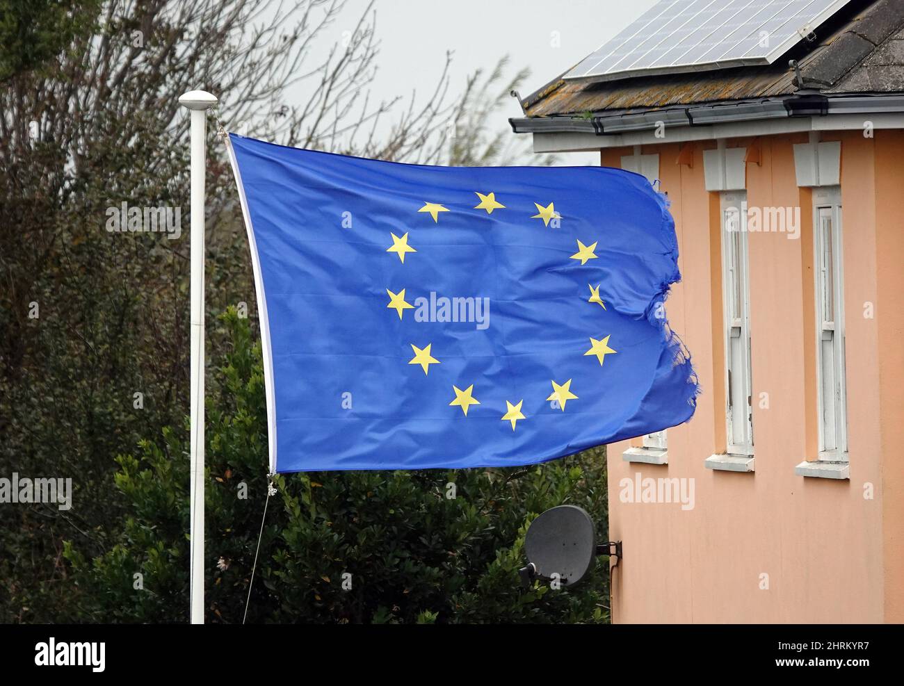 Worn and tattered EU flag flying on a flagpole in the UK Stock Photo