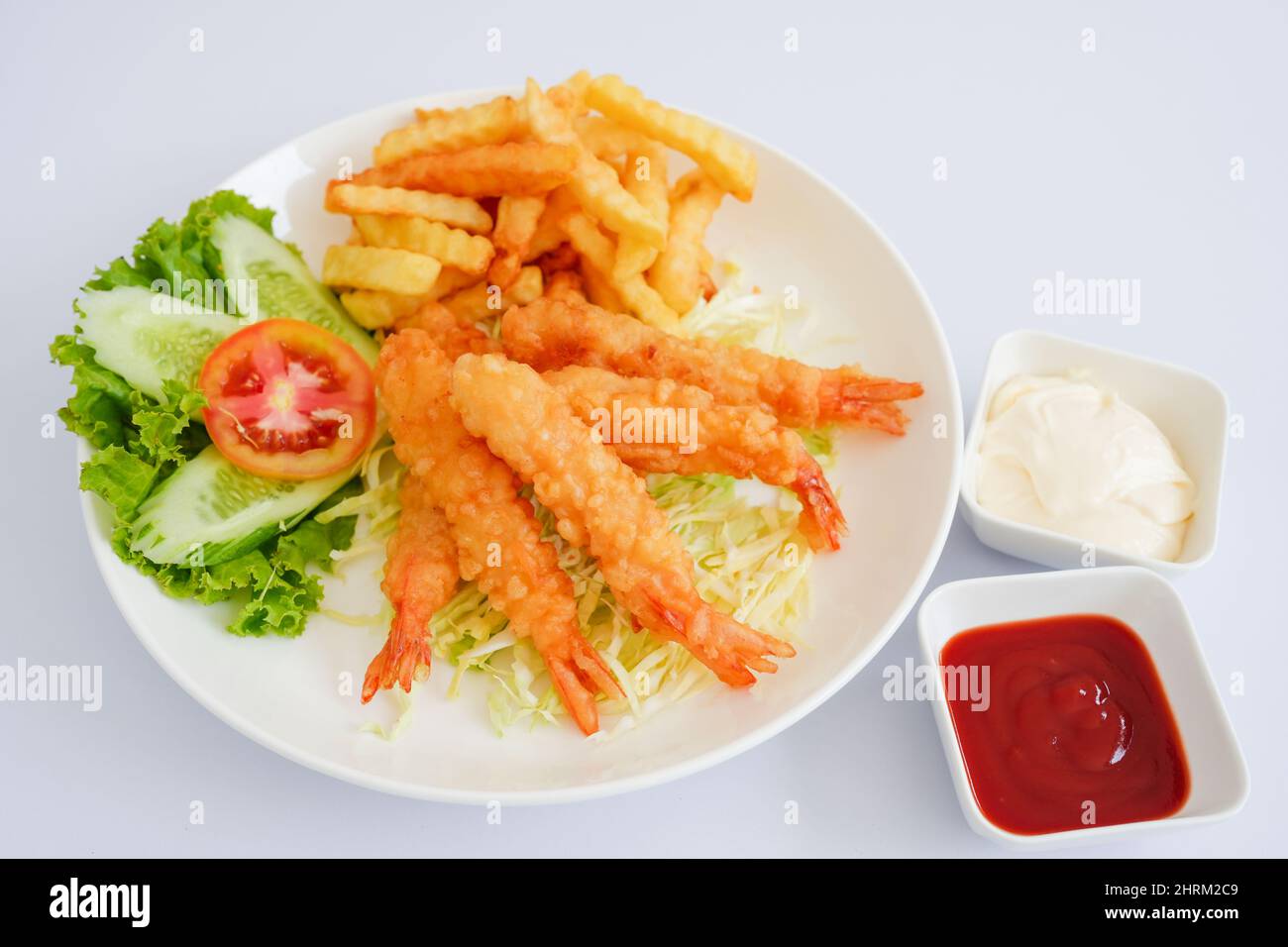 Serving of shrimp tempura with French fries, vegetables, ketchup, and