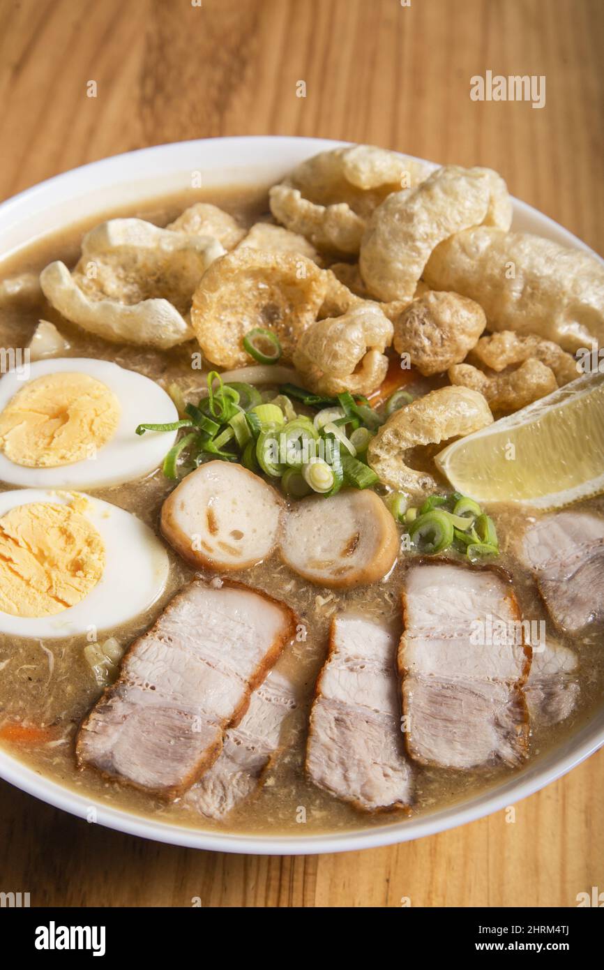 Thick egg noodles with fried pork belly on a white plate Stock Photo