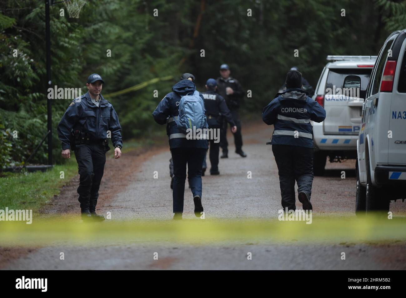 RCMP Officers And Members From The Coroner's Office Walk Into The Dense ...