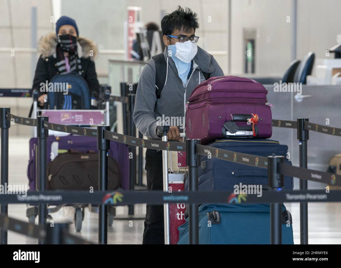 Passengers wear masks as they arrive for their flight at Pearson