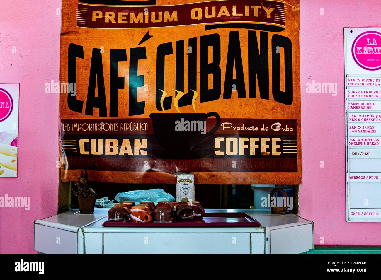 Premium quality Cuban coffee sign with cups and a small container of Cuban rum on a table at a restaurant in Havana, Cuba. sign with cups and a small Stock Photo