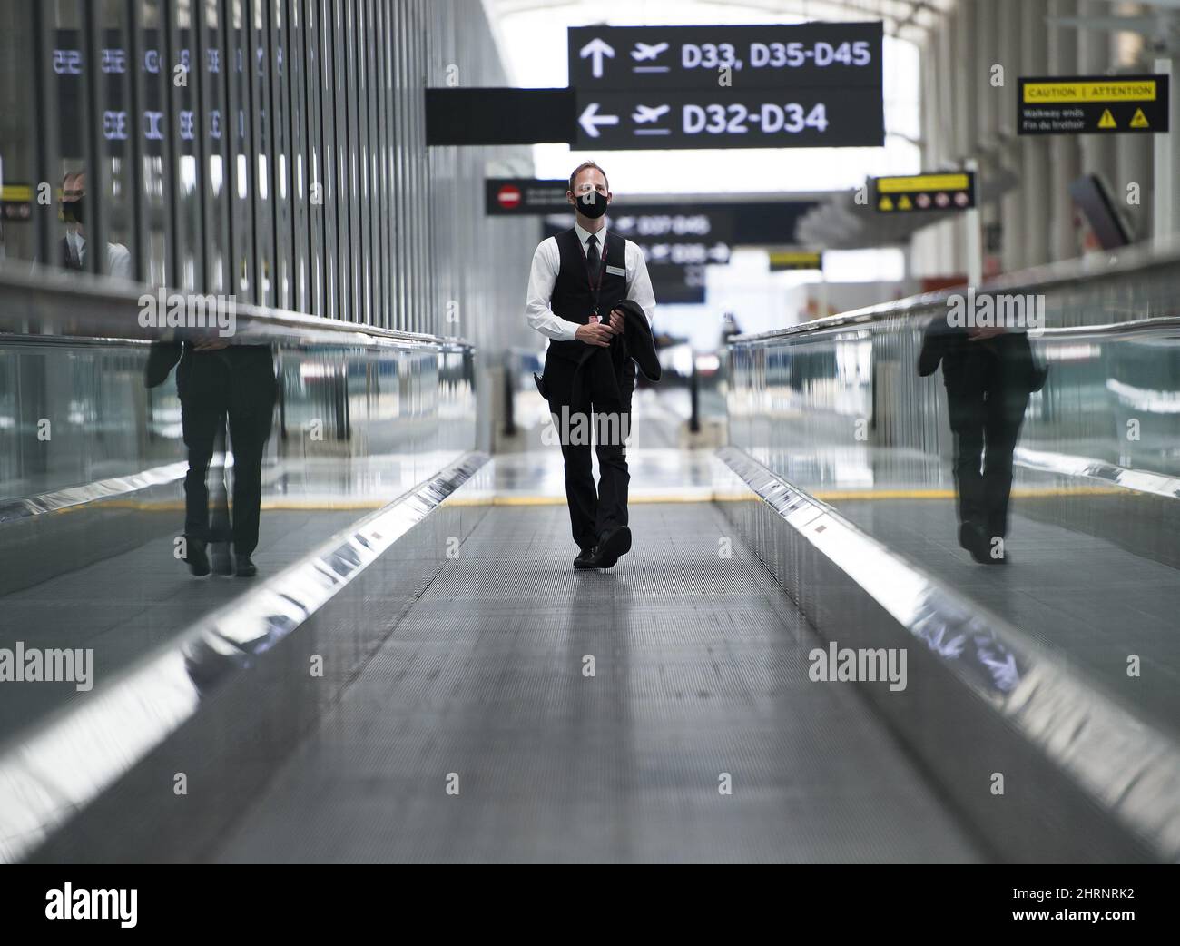 A man rides a escalator wearing mandatory masks at Toronto's Pearson