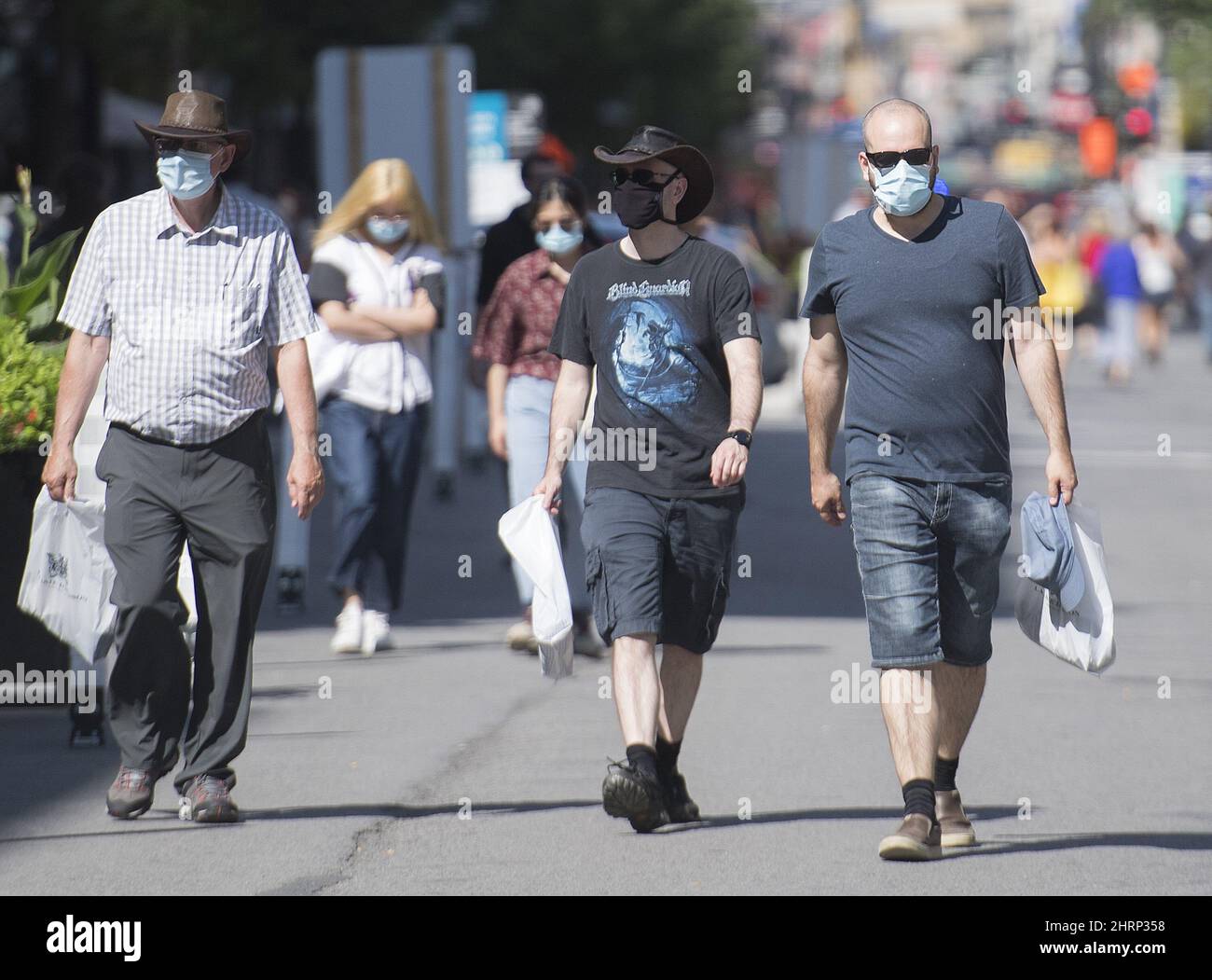 People wear face masks as they walk along Sainte Catherine Street in ...