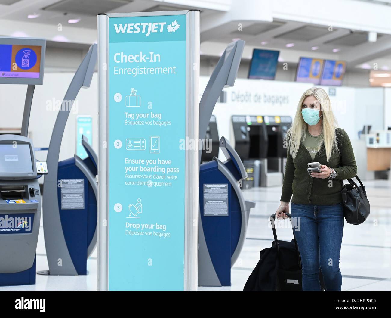 A woman walks through check in at WestJet at Pearson International airport during the COVID19