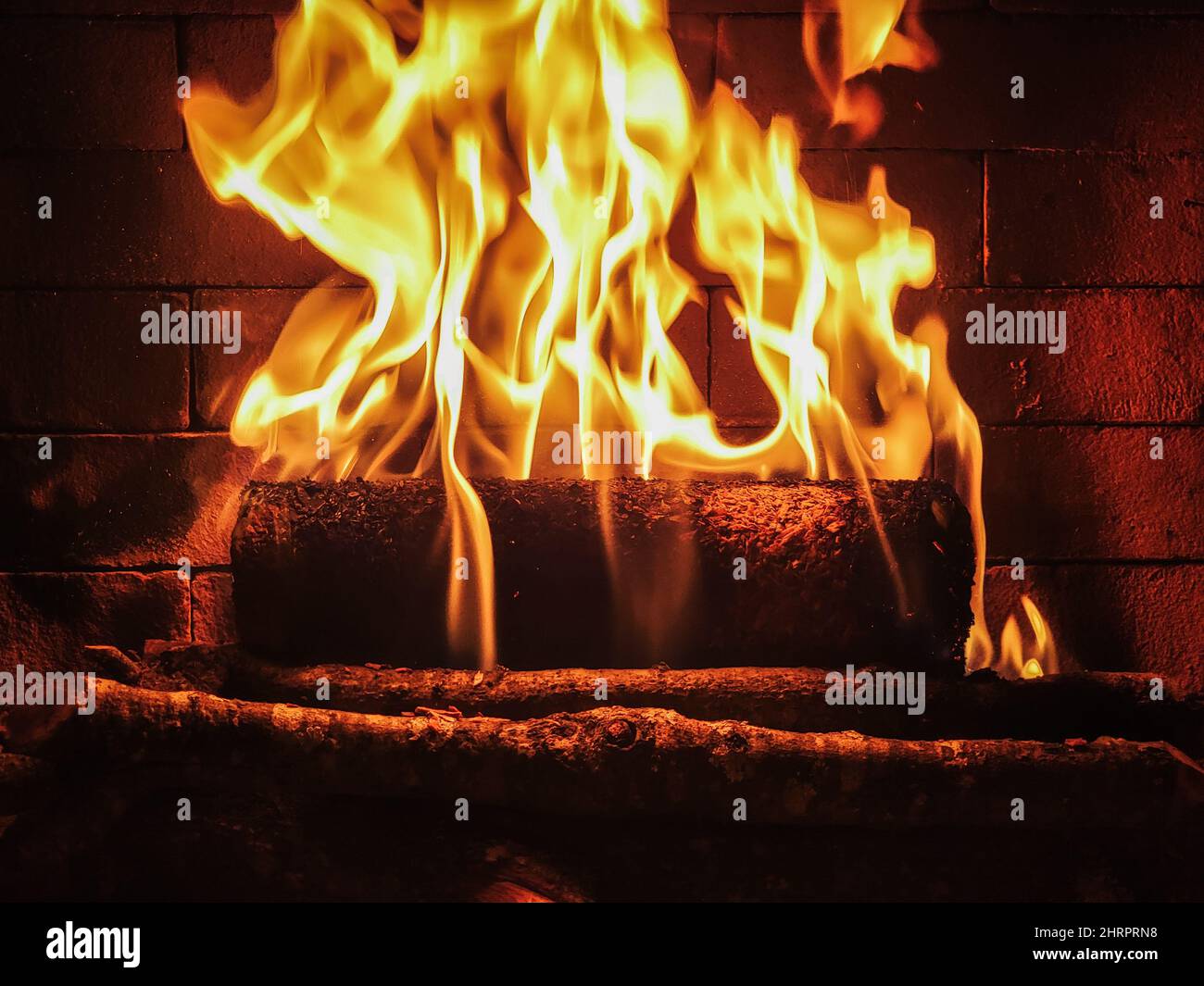 Closeup shot of burning woods on a brick fireplace Stock Photo