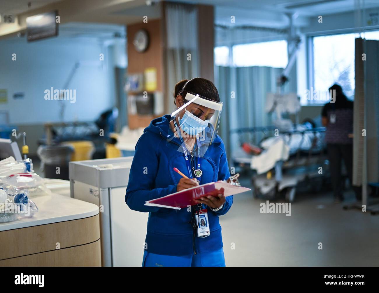 Healthcare worker Nalini Persaud looks at her clipboard in the