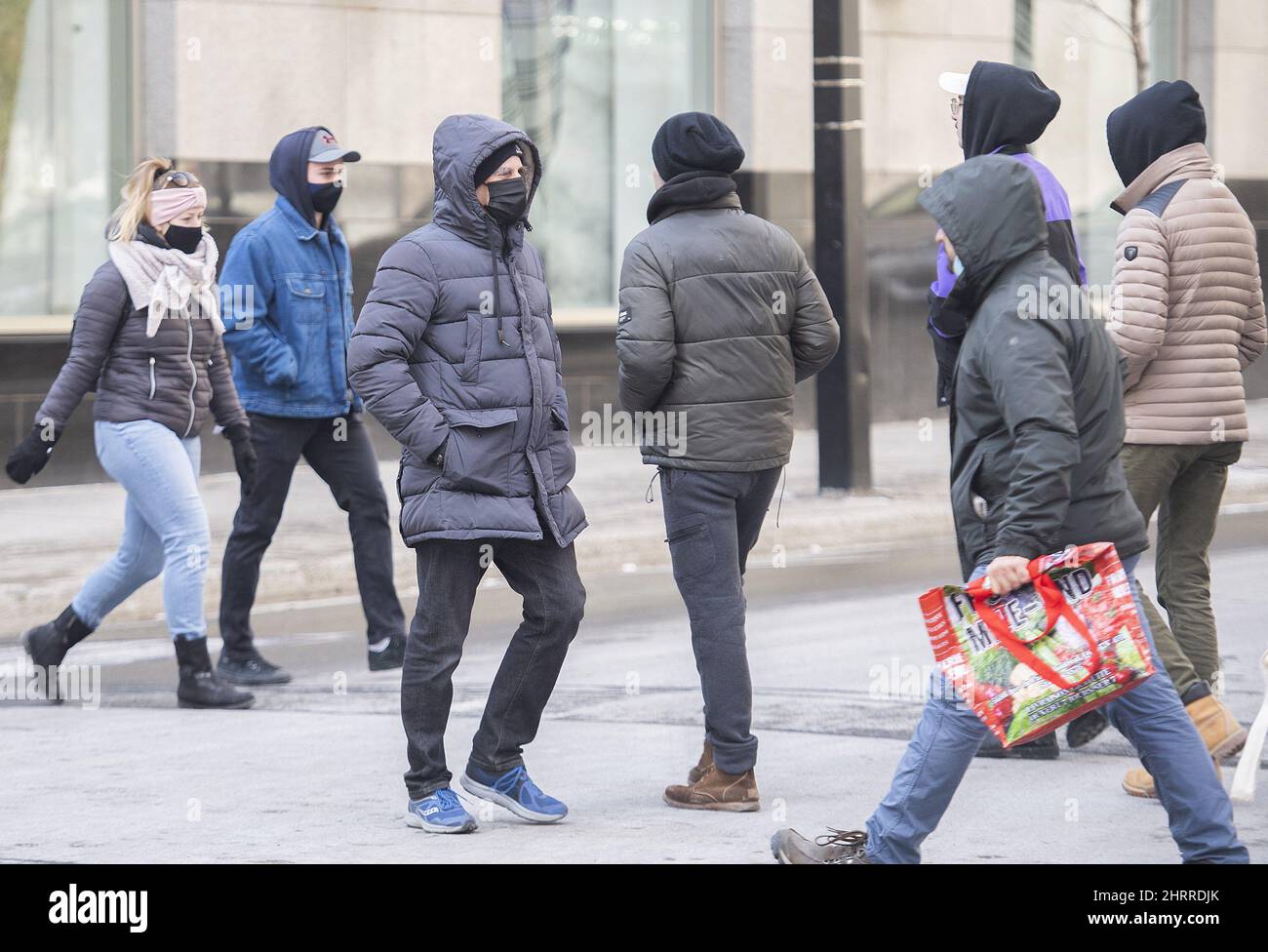 People wear face masks as they walk along a street in Montreal, Saturday, March 13, 2021, as the
