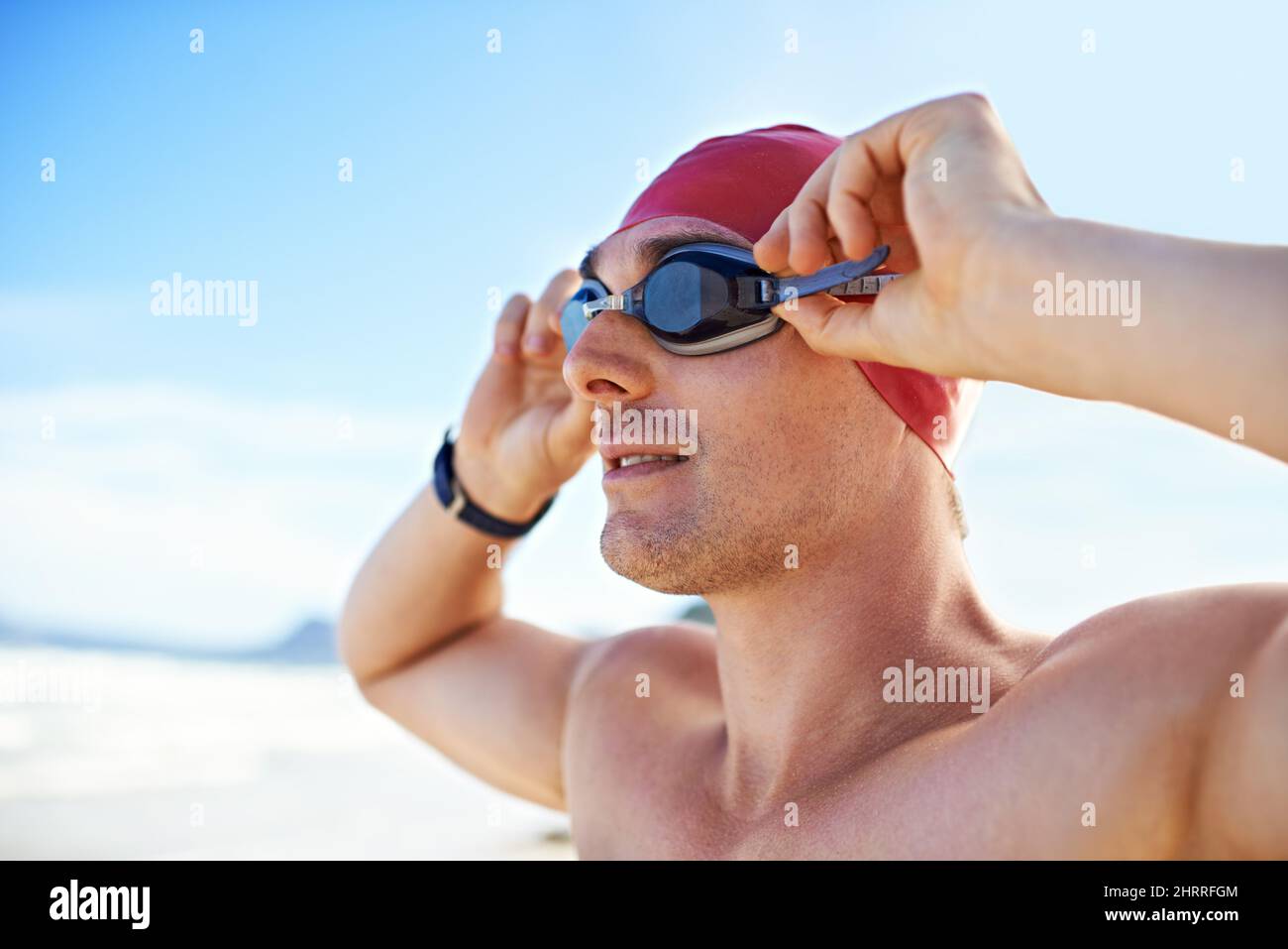 Goggles on. Cropped closeup shot of a man wearing swimming goggles looking out at the ocean. Stock Photo