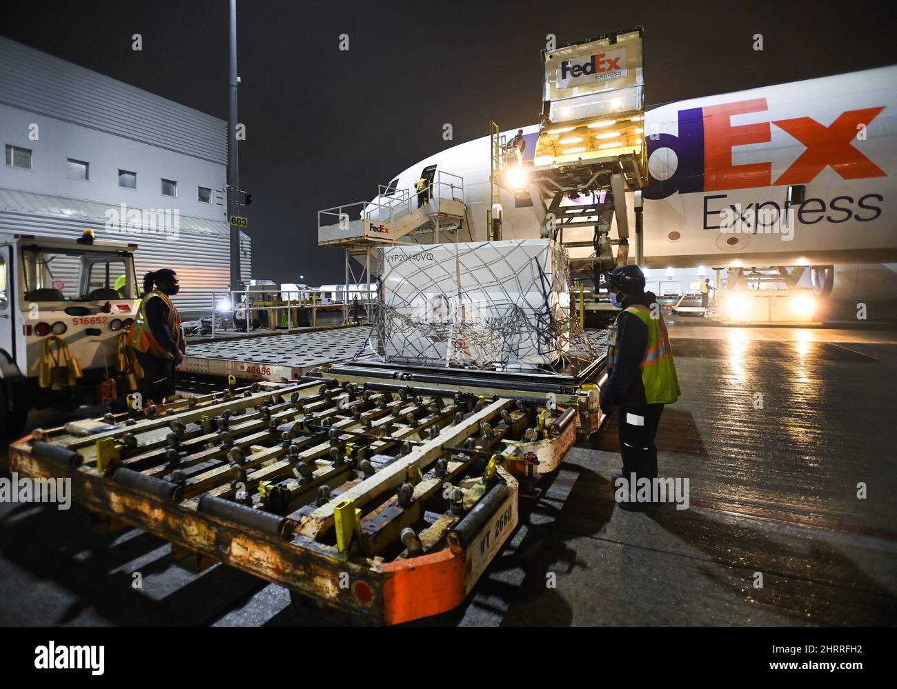 FedEx workers offload a plane carrying 255,600 doses of the Moderna