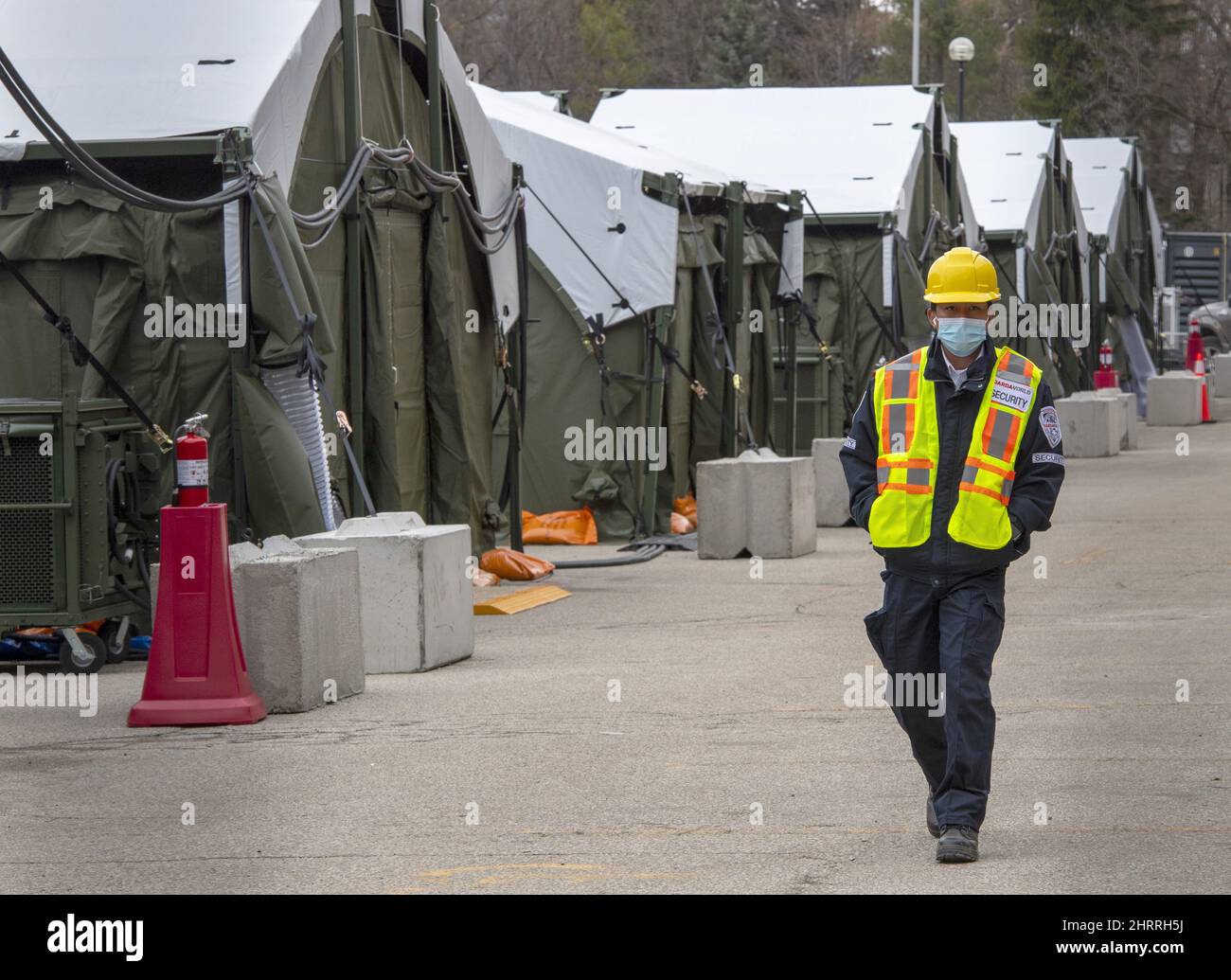 A security guard patrols at the field hospital in the parking lot of