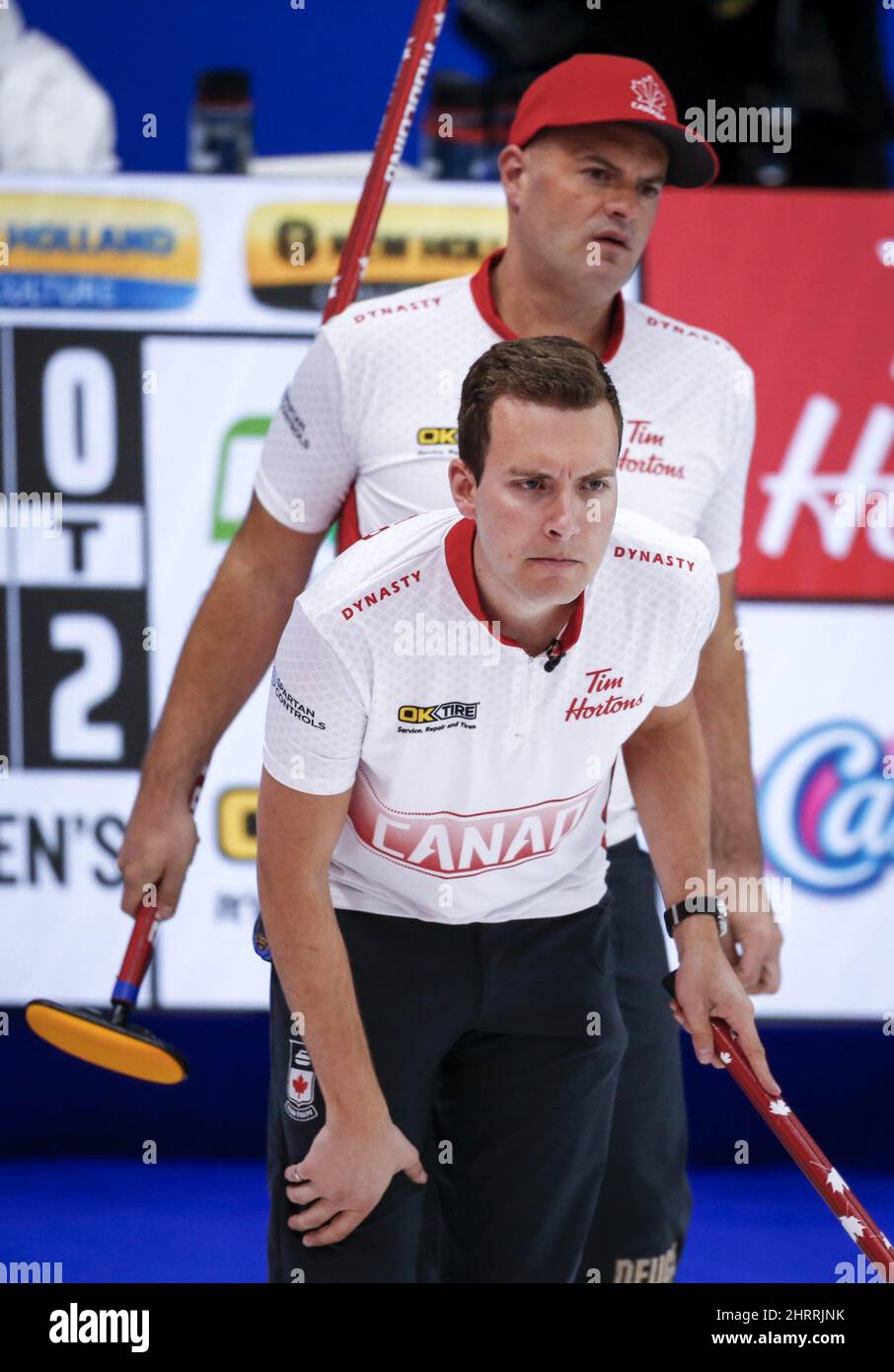 Team Canada skip Brendan Bottcher lines up a shot as third Darren Moulding looks on against