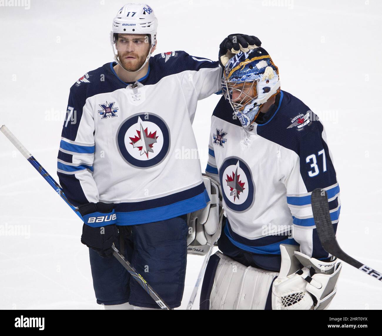 Winnipeg Jets goaltender Connor Hellebuyck (37) gets a pat on the head