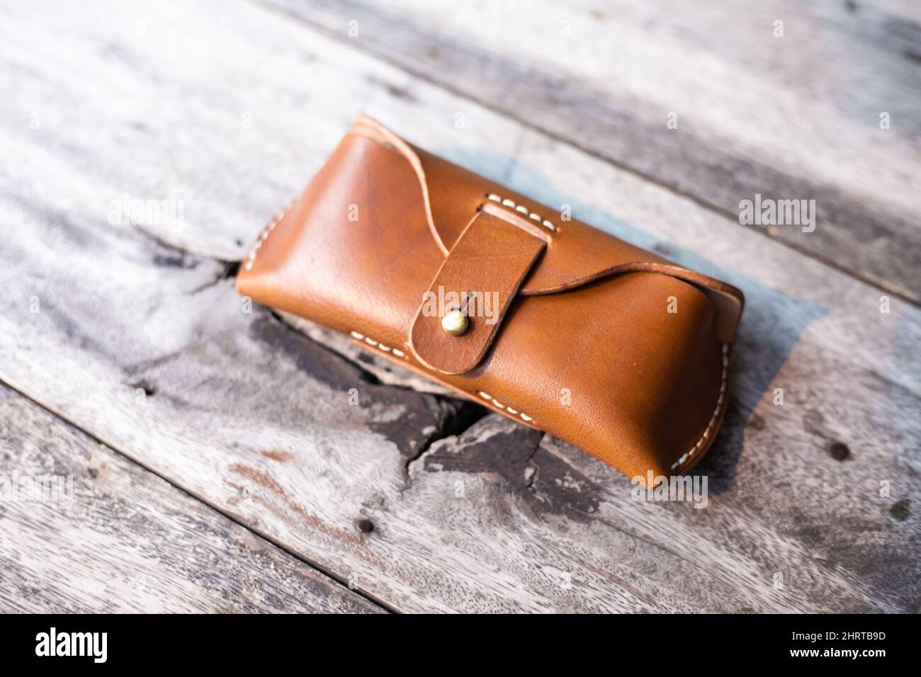 Brown genuine leather glasses case handmade working on wood, Leather goggle  bag Stock Photo - Alamy