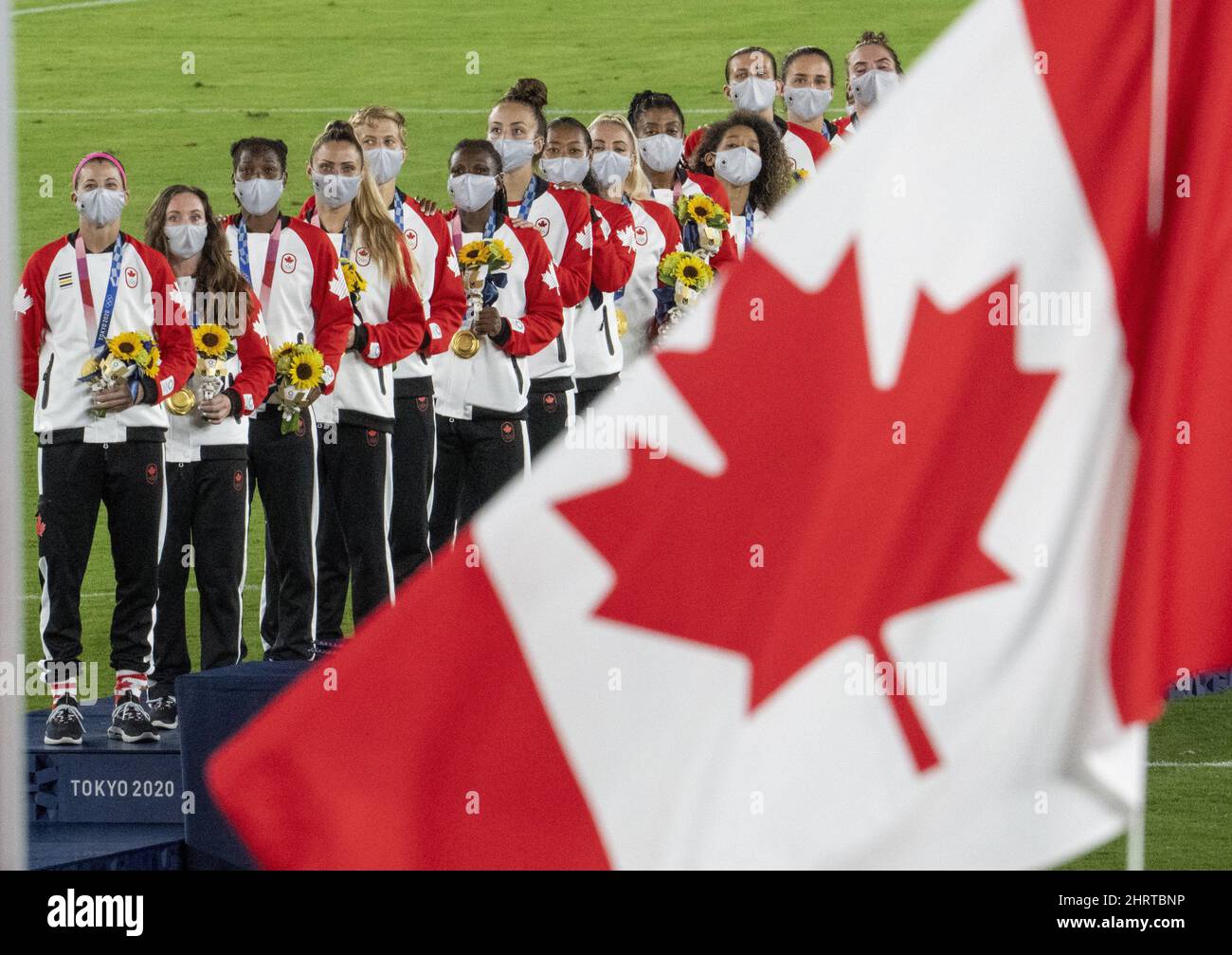 Members of the Canadian womenâ€™s soccer team watch the flag raise