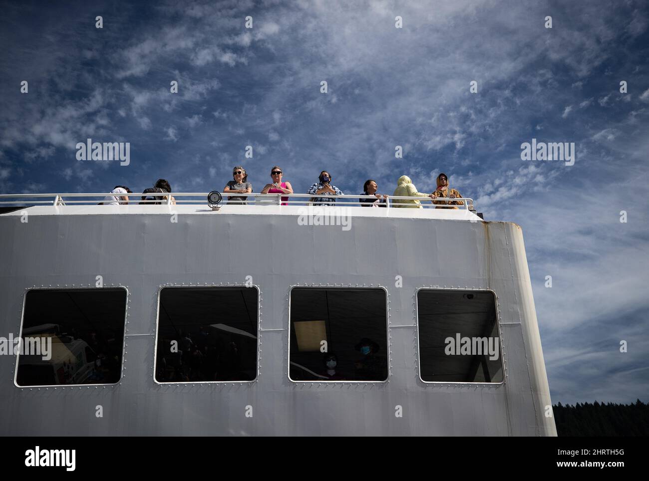 People stand on the passenger deck of the B.C. Ferries vessel Queen of
