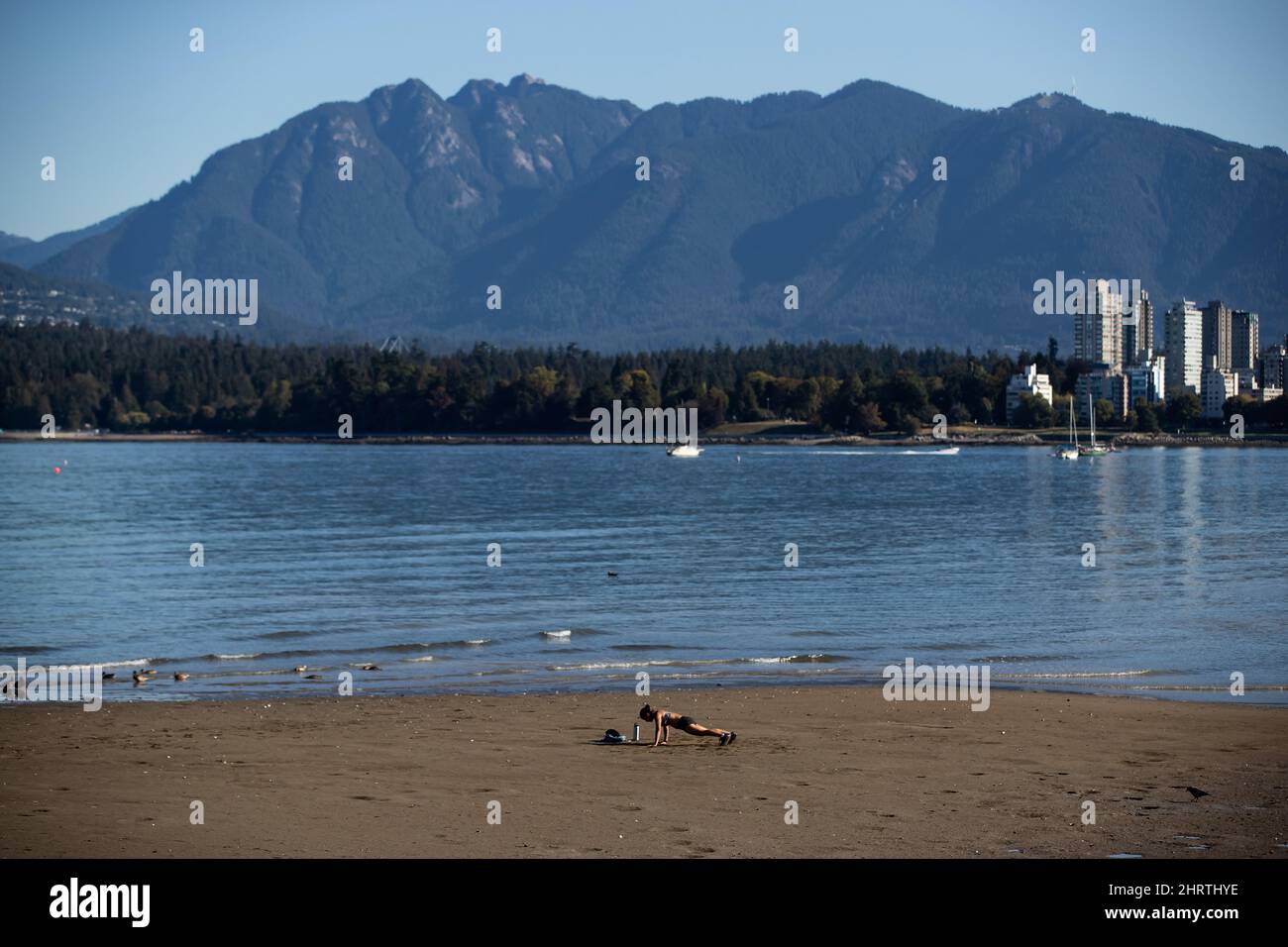 A woman exercises during low tide at Kitsilano Beach in Vancouver, on Thursday, September 2