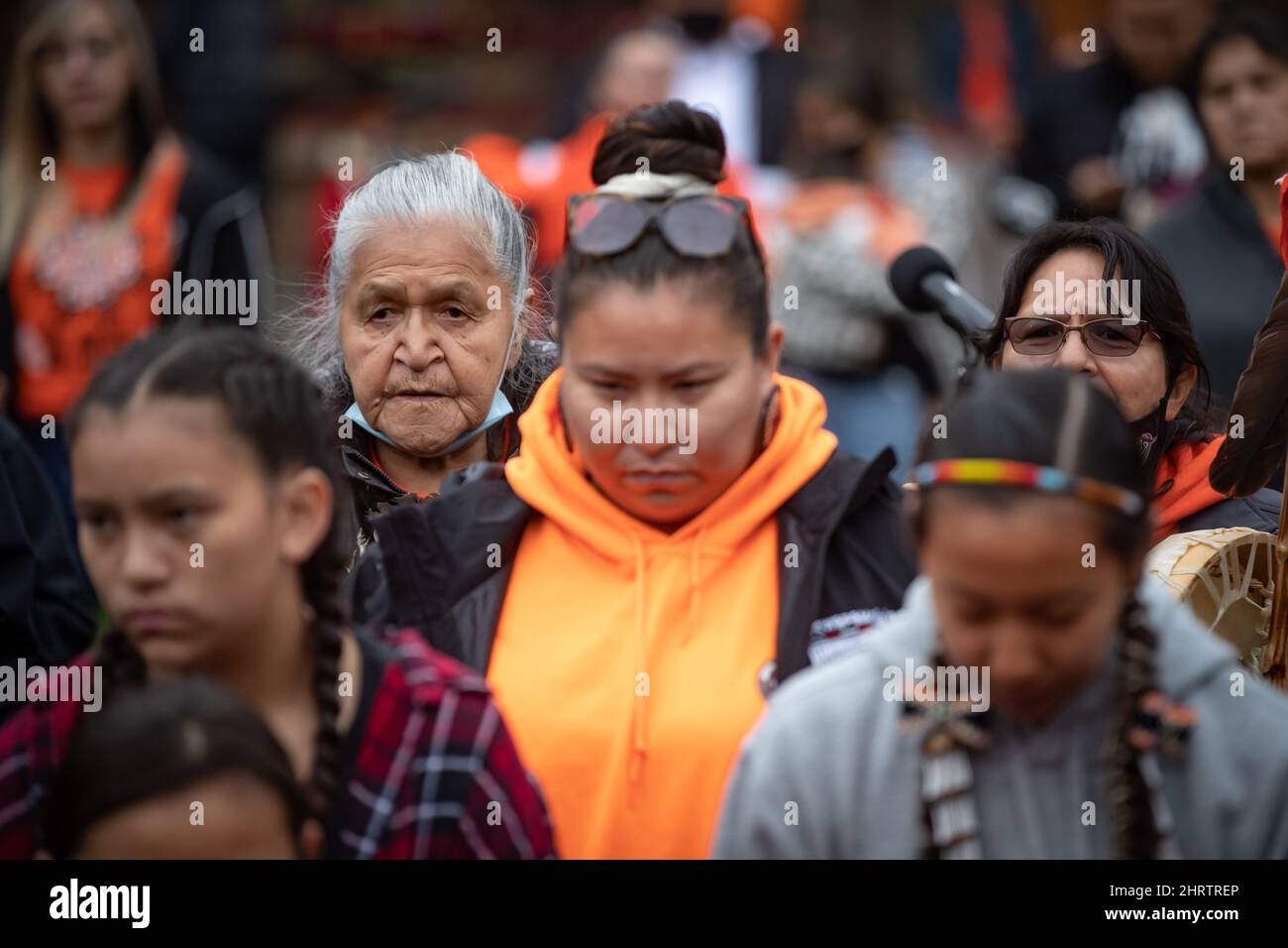 Kamloops Indian Residential School survivor Camille Kenoras, back left, 82, listens as drummers