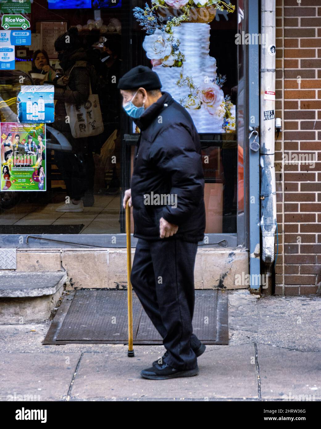 Vertical shot of a male with a crutch in the street, Chinatown