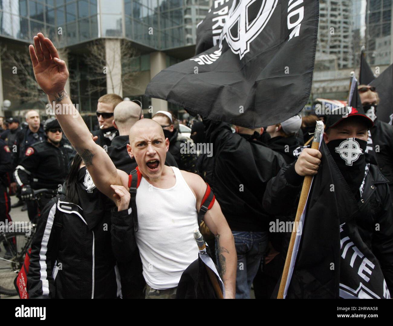 An Aryan Guard supporter salutes at White Pride rally as he yells at anti-racsim supporters in Calgary, Alberta, Canada on Saturday, March 21, 2009. Over 500 people turned out to protest the march and clashed with Aryan Guard supporters. Police detained several people during the event. (AP Photo/The Canadian Press, Jeff McIntosh) Stock Photo