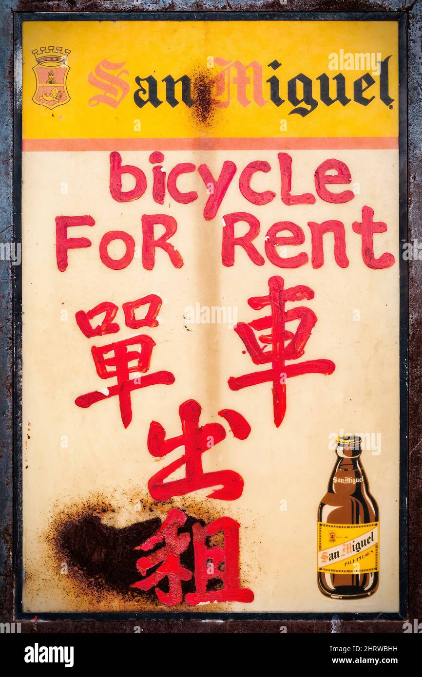 A beer-branded menu board repurposed as a bilingual Chinese and English sign for bicycle rental on the Outlying Island of Cheung Chau, Hong Kong Stock Photo