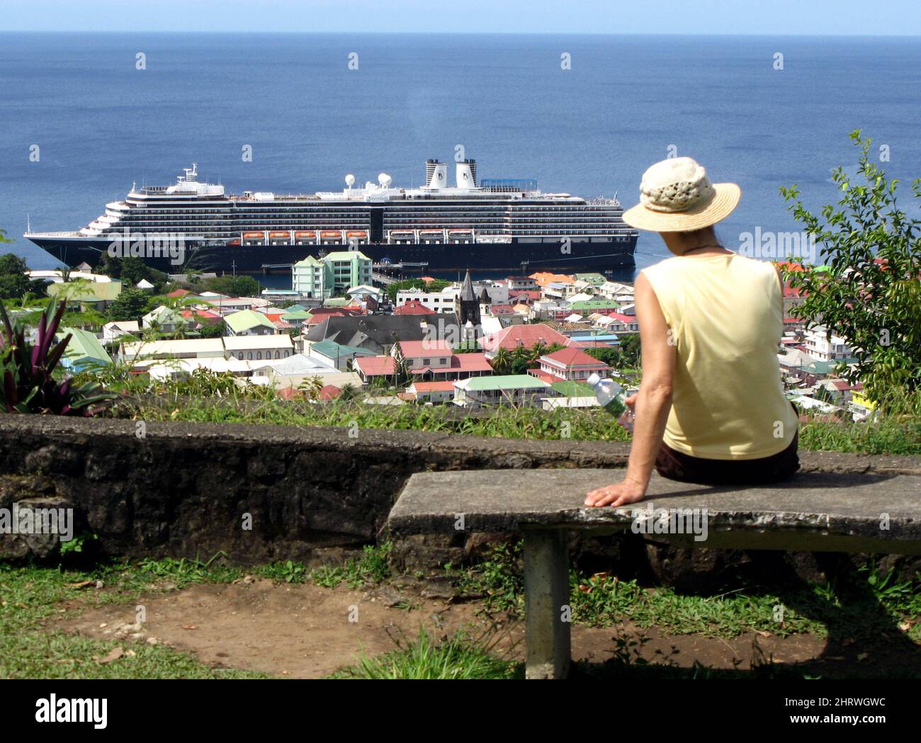 A tourist looks out over Roseau, Dominica, while the Holland America line cruise ship MS Noordam sit in the port city, Feb. 26, 2009.THE CANADIAN PRESS IMAGES/Jeff McIntosh Stock Photo