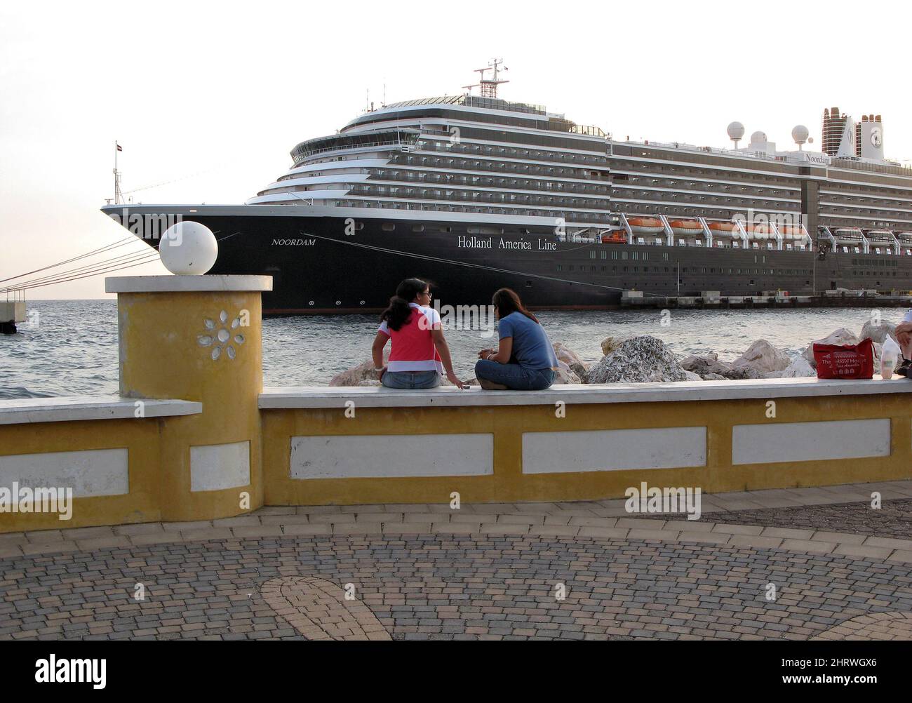 Local teens sit on a wall as the Holland America Line cruise ship MS Noordam sits at a dock in Willemstad, Curacao, Netherlands Antilles, Feb. 28, 2009.THE CANADIAN PRESS IMAGES/Jeff McIntosh Stock Photo