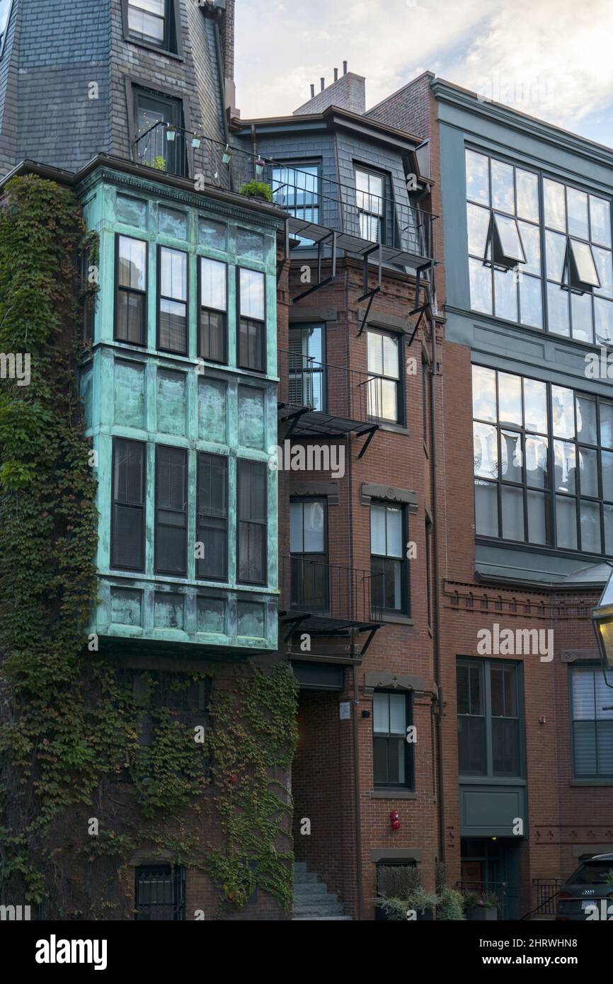 Historic brownstone houses with big windows and copper teal wall in ...