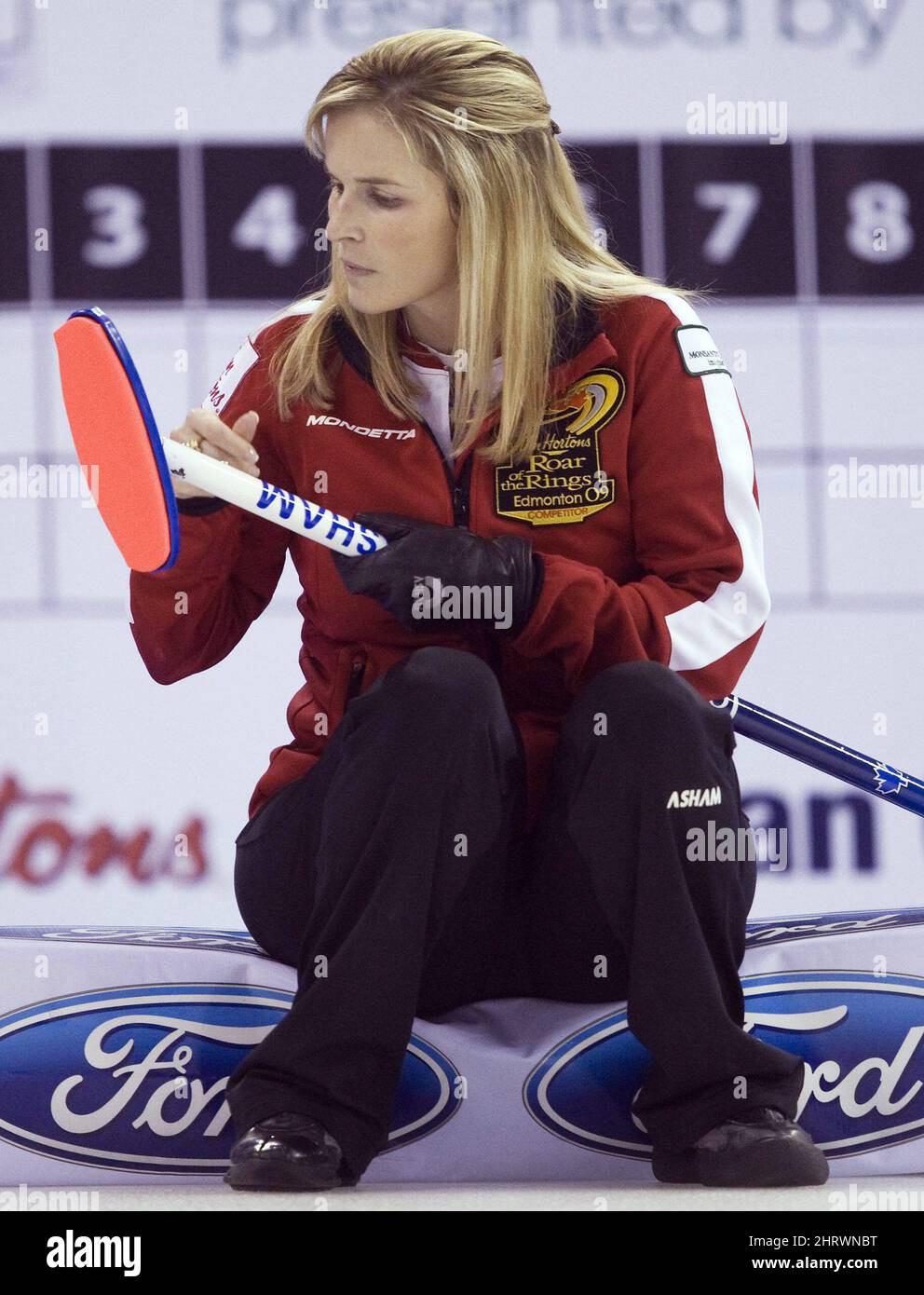 Skip Jennifer Jones cleans her broom during a draw against Team Holland