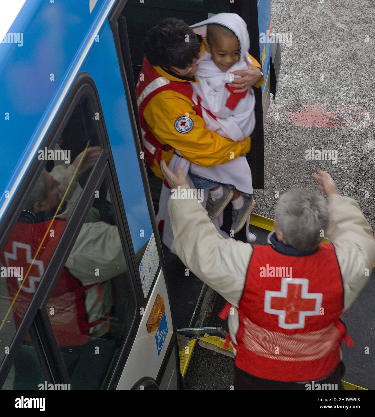 A smiling young child is welcomed by Red Cross personnel at Pierre Trudeau Airport in Montreal after arriving from Haiti early Sunday morning, January 17, 2010. THE CANADIAN PRESS/Peter McCabe Stock Photo