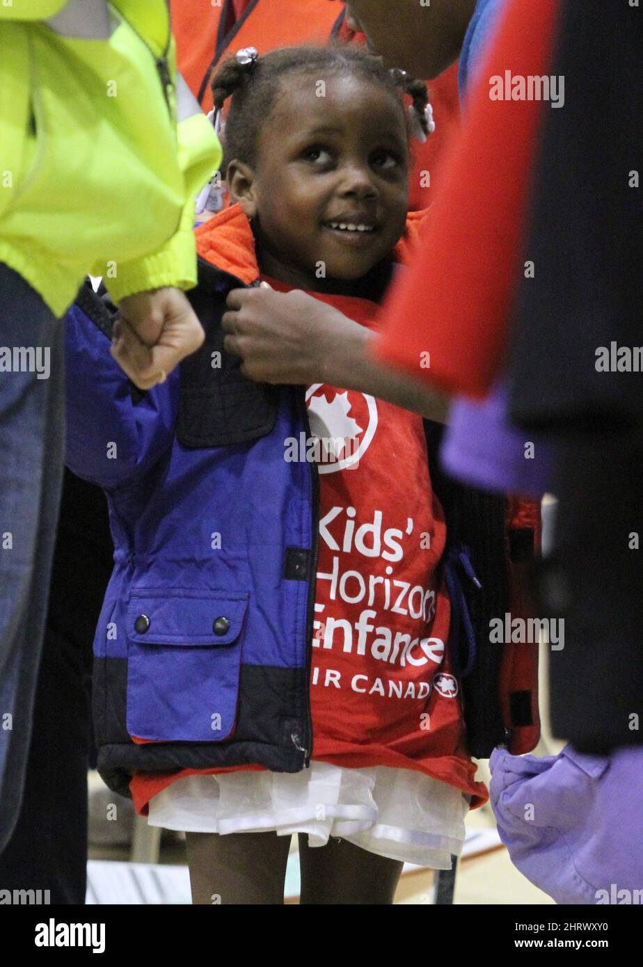 A girl tries on a winter jacket after she and her family were evacuated