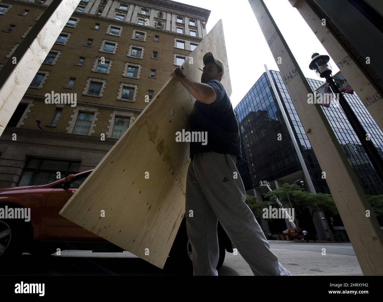 Workers install plywood sheets on street level condos in Toronto