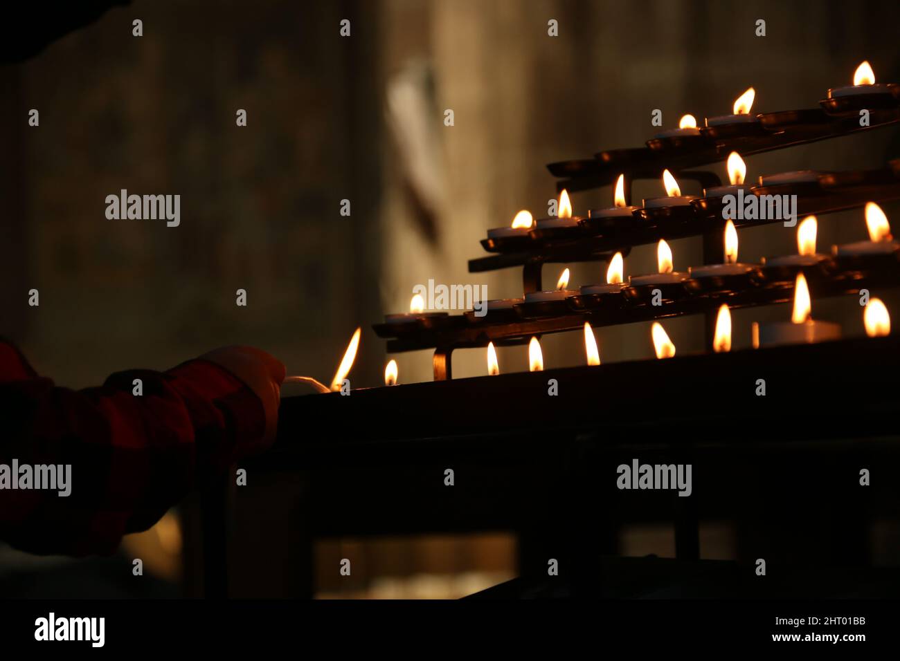 Person's hand lighting candle in a church Stock Photo - Alamy