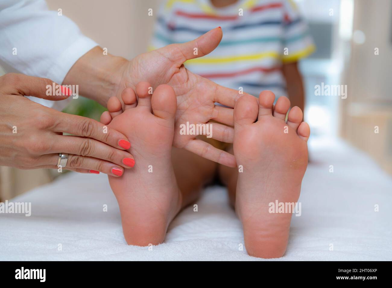 Pediatrician examining a boy's feet Stock Photo