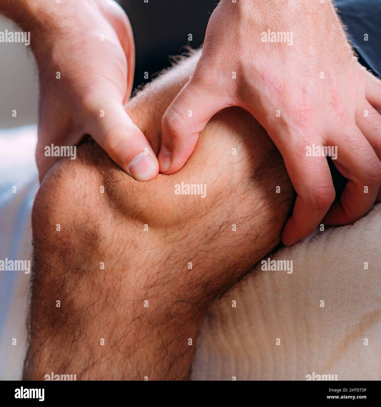 Physiotherapist massaging an injured knee Stock Photo