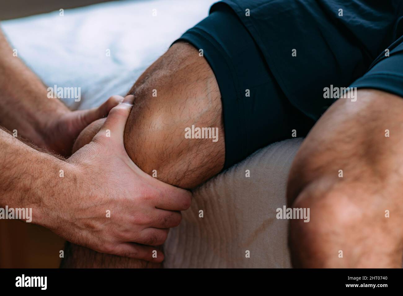 Physiotherapist massaging an injured knee Stock Photo
