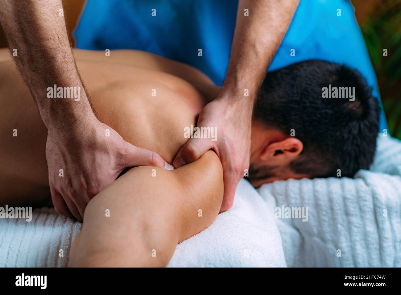 Physiotherapist massaging patient's shoulder Stock Photo