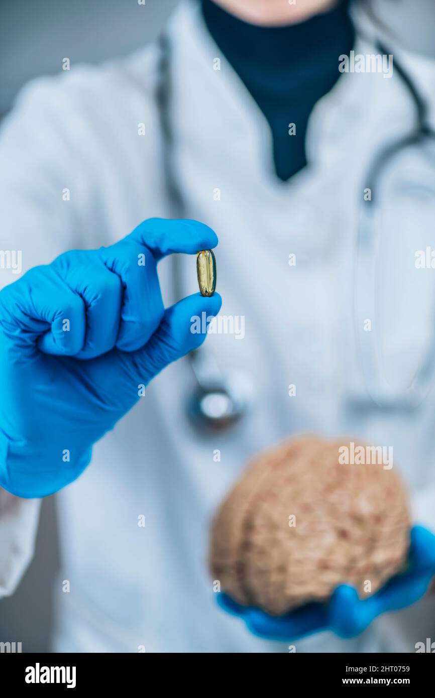 Female doctor holding model of brain and a placebo pill Stock Photo